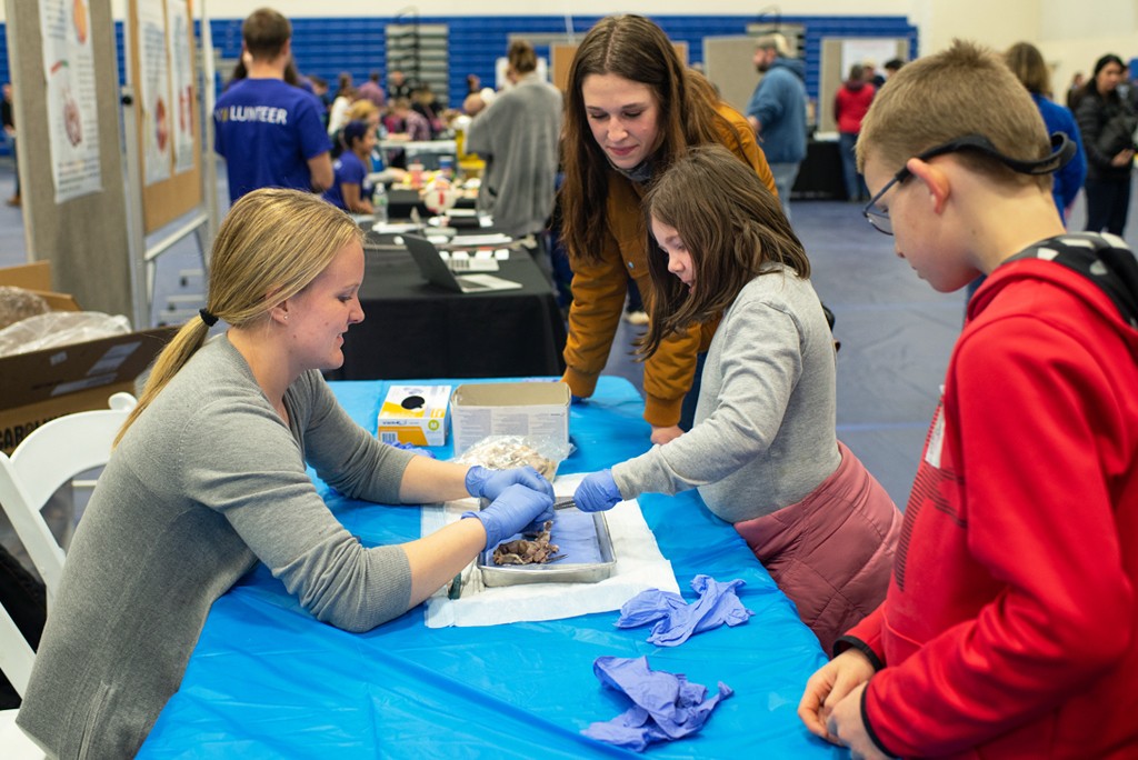 A ֱ student works with kids during the CEN Brain Fair event