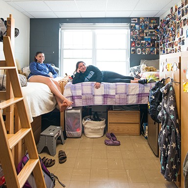 Two ֱ Students watching television in their dorm room